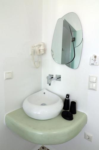 a bathroom with a sink and a mirror at Vino suites in Agia Anna Naxos