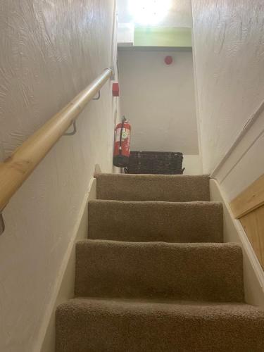 a stairway with stairs with a suitcase on it at Abbey GH All Rooms En-Suite in Redcar