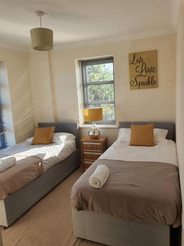 a bedroom with two beds and a sign that reads i love panic at Vetrelax Colchester Apartment in Colchester