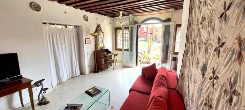 a living room with a red couch and a tv at Elisabeth Waterfront Apartment in Venice