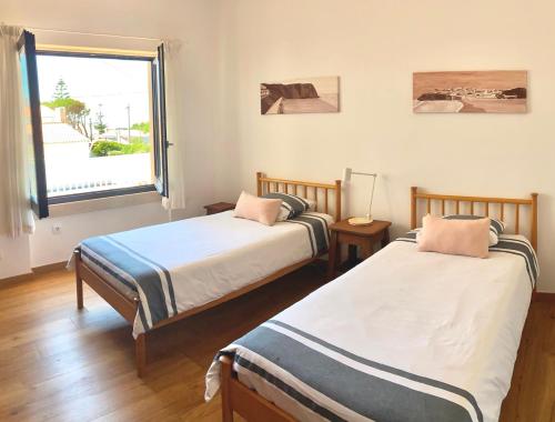 due letti in una stanza con finestra di Colares beach house, pool child friendly a Colares