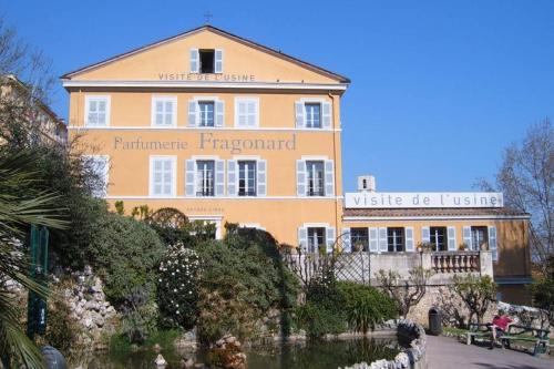 d'un grand bâtiment jaune avec un panneau. dans l'établissement 3 pièces neuf au pied des musées - Wifi & Parking, à Grasse