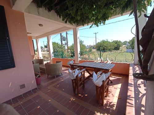 a patio with a table and chairs and a window at Olgas Villa in Aroyí
