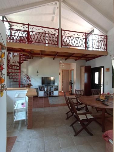 a living room with a balcony and a table with chairs at Olgas Villa in Aroyí