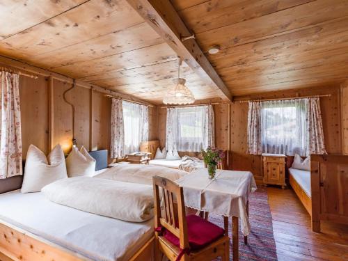 a bedroom with two beds and a table in a room at Grindlalm in Zell am Ziller
