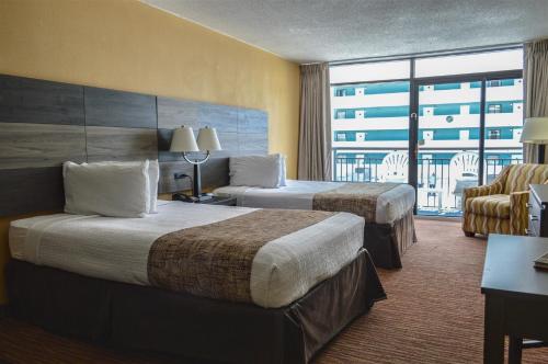 um quarto de hotel com duas camas e uma varanda em Landmark 704 em Myrtle Beach