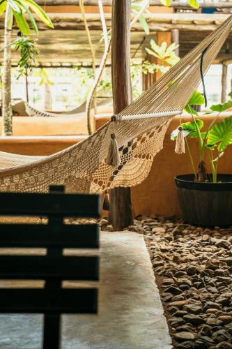 a hammock in a room with plants in it at El Sitio de Playa Venao in Playa Venao