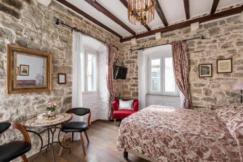 1 dormitorio con 1 cama, mesa y sillas en Apartments Kaleta, en Split