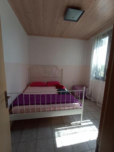 a bedroom with a bed with purple sheets and a wooden ceiling at Olgas Villa in Aroyí