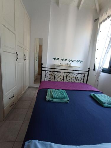 a bedroom with a blue bed with two green towels at Olgas Villa in Aroyí