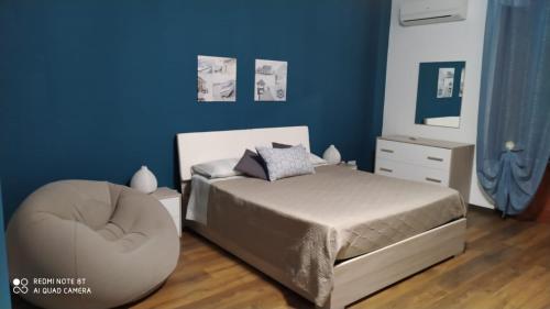 a bedroom with a bed and a ottoman at Domus Mea in Trabia