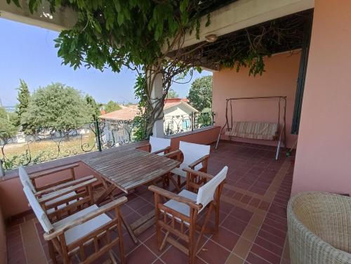 a patio with a wooden table and chairs on a balcony at Olgas Villa in Aroyí