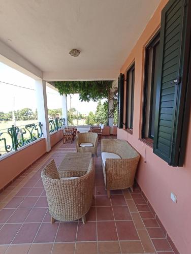 a balcony with wicker chairs and tables and windows at Olgas Villa in Aroyí