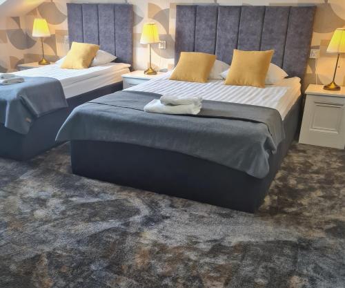 two beds in a hotel room with towels on them at Pensjonat Retro in Łomża