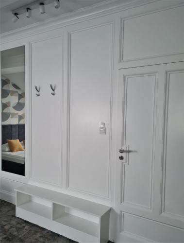 a white wardrobe with glass doors in a bedroom at Pensjonat Retro in Łomża