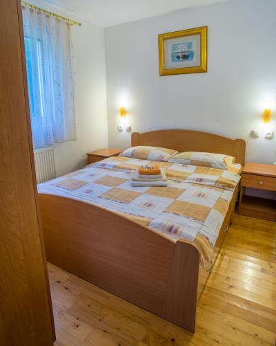 a bedroom with a large bed with a wooden floor at Knežević Apartment in Žabljak