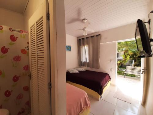 - une chambre avec un lit et une porte coulissante en verre dans l'établissement PousadaRecanto684Guarujá, à Guarujá