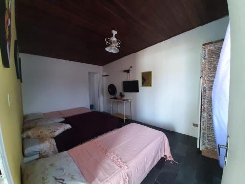 a bedroom with a bed with a pink blanket at PousadaRecanto684Guarujá in Guarujá