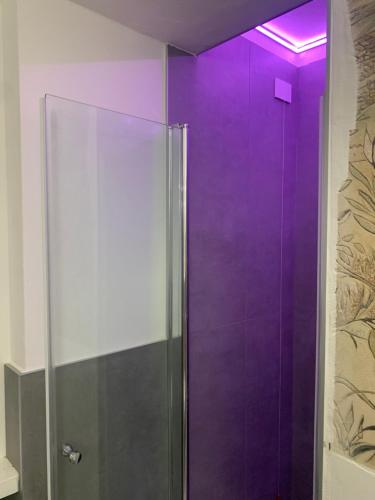 una doccia viola con porta in vetro in bagno di Volta's Dream a Como