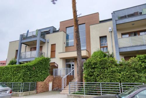 an apartment building with a palm tree in front of it at Apartments IN - Międzywodzie in Międzywodzie