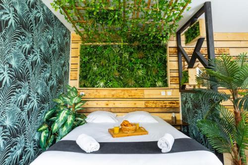 - une chambre dotée d'un lit avec un mur vert dans l'établissement Kawaii - Domaine Tropical, à Saint-Aignan