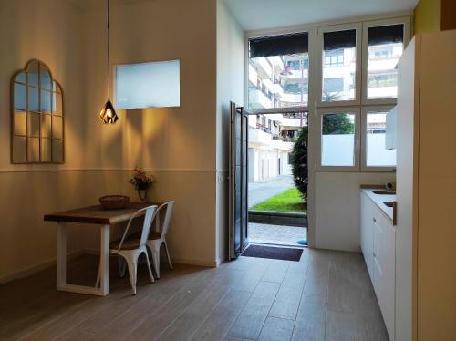 une petite cuisine avec une table et une fenêtre dans l'établissement Kaixo MARINA con Parking gratis, à Zarautz