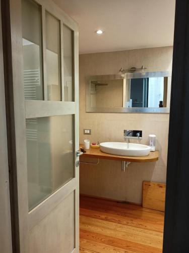 a bathroom with a sink and a mirror and a door at Il piccolo loft in Manziana