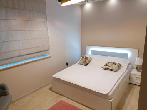 1 dormitorio pequeño con 1 cama blanca y 2 almohadas en LABORATORIUM PIĘKNA, en Łeba
