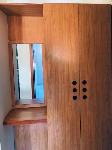 a wooden cabinet with a mirror on it at CONDOMÍNIO VILA DO MAR in Aquiraz