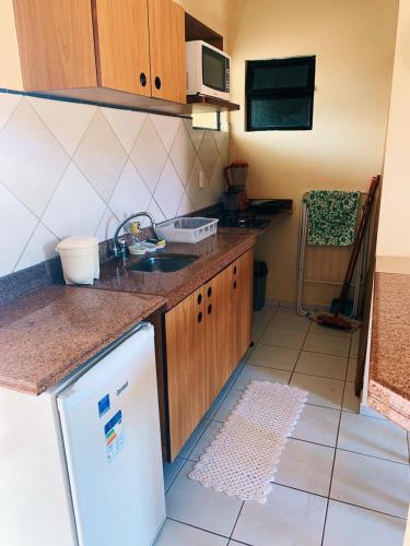 a small kitchen with a sink and a refrigerator at CONDOMÍNIO VILA DO MAR in Aquiraz