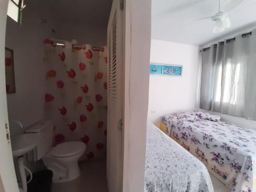 a bedroom with two beds and a toilet and a sink at PousadaRecanto684Guarujá in Guarujá