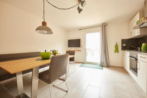 a kitchen and dining room with a wooden table and chairs at Ferienwohnungen Weingut und Vinothek Regnery in Klüsserath