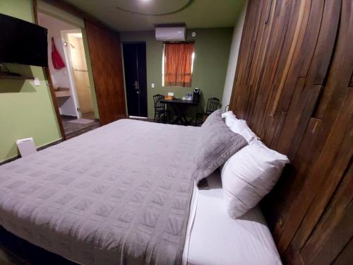 a bedroom with a large bed with a wooden headboard at Independencia Dos 7 Hotel Boutique in Querétaro