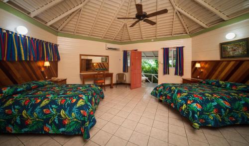 Samsara Cliff Resort في نيغريل: غرفة نوم بسريرين ومروحة سقف