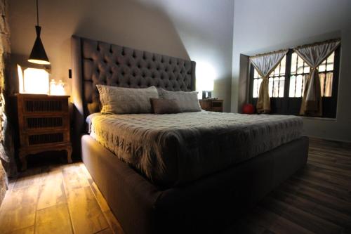 a bedroom with a large bed with a large headboard at Independencia Dos 7 Hotel Boutique in Querétaro