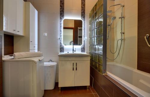 a bathroom with a sink and a toilet and a shower at Lodz4u - Apartament Monopolis z garażem - BON TURYSTYCZNY in Łódź