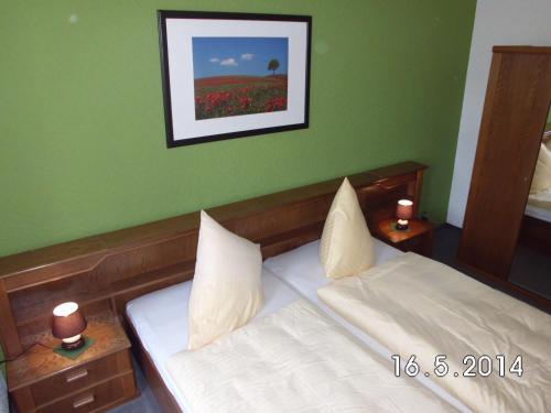 a bedroom with two beds and a picture on the wall at Hotel garni am Thüringer KloßTheater in Friedrichroda