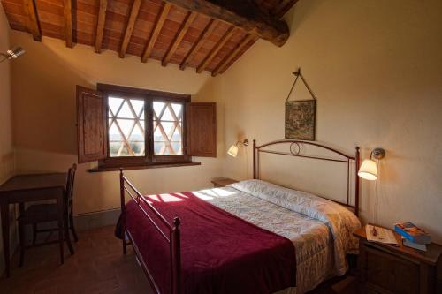 カステルヌオーヴォ・ベラルデンガにあるAgriturismo Podere Fornacinoのベッドとテーブルと窓のある寝室