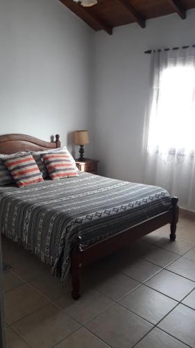 ein Bett in einem Schlafzimmer mit einem Fenster in der Unterkunft Apartamento La Felicidad in Tandil