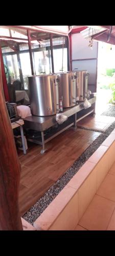 a row of large metal vats sitting on a wooden floor at Hotel la Cueva Limon in Puerto Limón