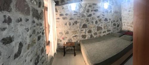 sypialnia z łóżkiem w kamiennej ścianie w obiekcie Denizkızı Apart w mieście Küçükköy