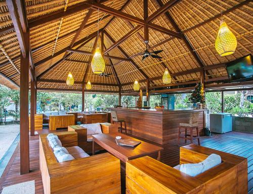 an outdoor restaurant with wooden tables and chairs at Sukanusa Luxury Huts in Nusa Lembongan