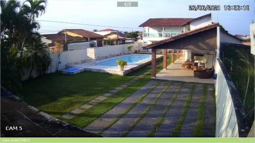 Vista sulla piscina di Itanhaém Maravilhosa, Bilhar, Sky, WiFi, Piscina e churrasqueira grande, Gramado, Casa linda de alto padrão a 600m praia o su una piscina nei dintorni