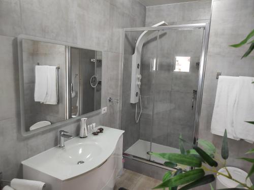 a bathroom with a shower and a sink and a mirror at Romantico open space Luna in Orosei