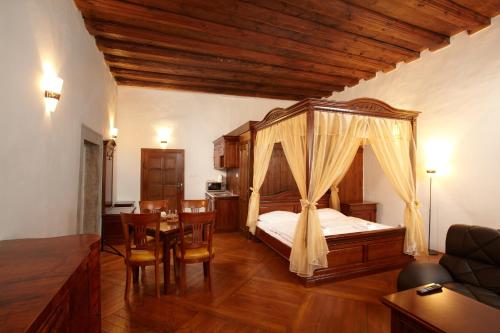 a bedroom with a bed and a table and chairs at Residence Muzeum Vltavínů in Český Krumlov