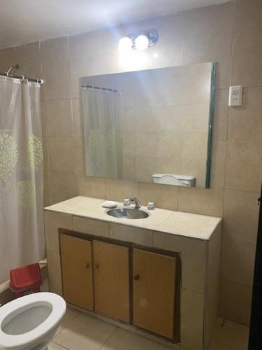 ein Badezimmer mit einem Waschbecken, einem WC und einem Spiegel in der Unterkunft Tres Marías in Alto de Sierra