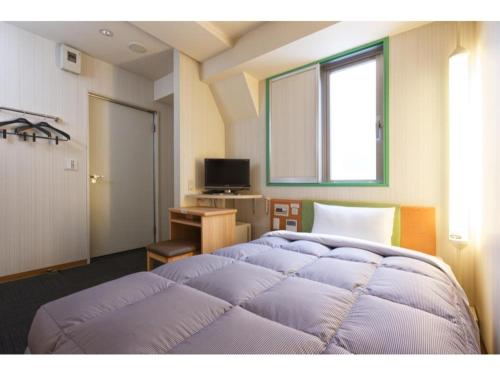 1 dormitorio con 2 camas, escritorio y ventana en R&B Hotel Kobe Motomachi - Vacation STAY 15385v en Kobe