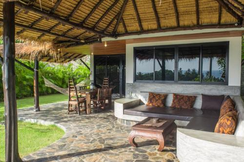an outdoor patio with a couch and a table at Koh Tao Heights Boutique Villas in Koh Tao