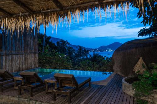 a patio with a table and chairs and a swimming pool at Koh Tao Heights Boutique Villas in Koh Tao