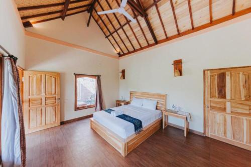 una camera con un grande letto e un soffitto in legno di The Asri Villas a Jembrana